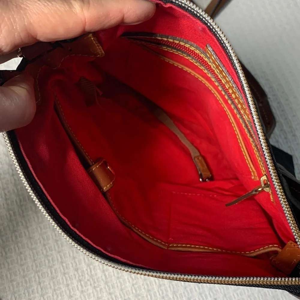 Dooney & Bourke black nylon crossbody bag with brown leather strap and accents